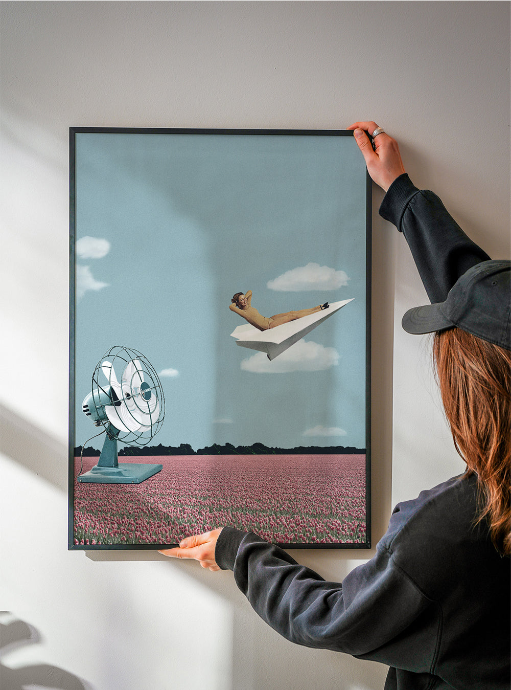 Ilustrace papírového letadla nad růžovým polem