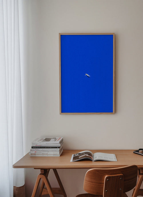 Minimalistický obraz s vznášející se postavou na modré obloze