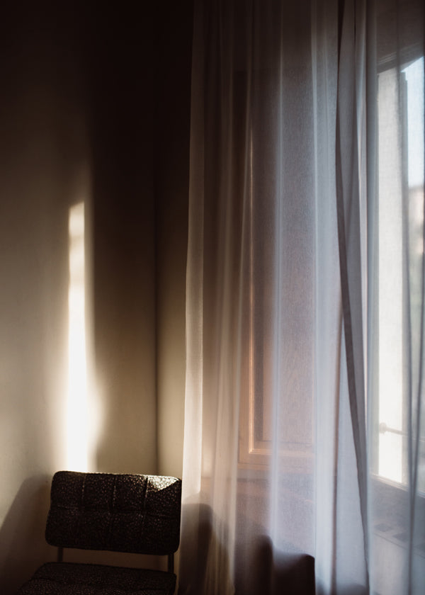Fotografie okna a závěsu s jemným světlem