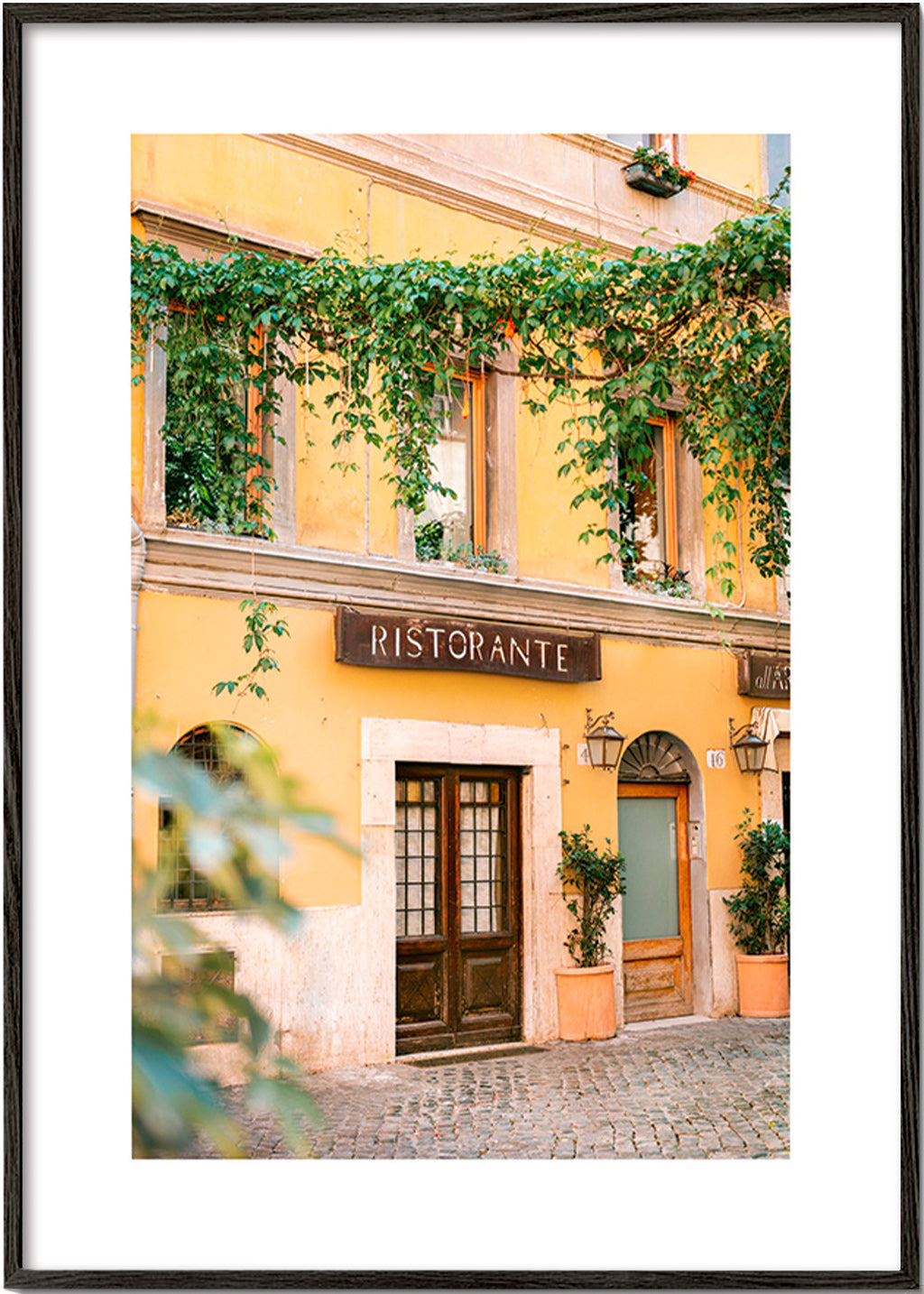 Obraz do kuchyně: fasáda ristorante v teplé žluté – Black Frame