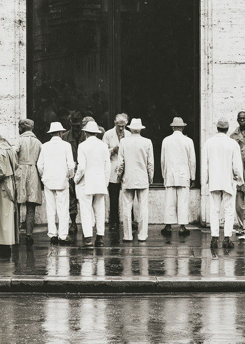 Černobílá fotografie mužů zezadu v dešti